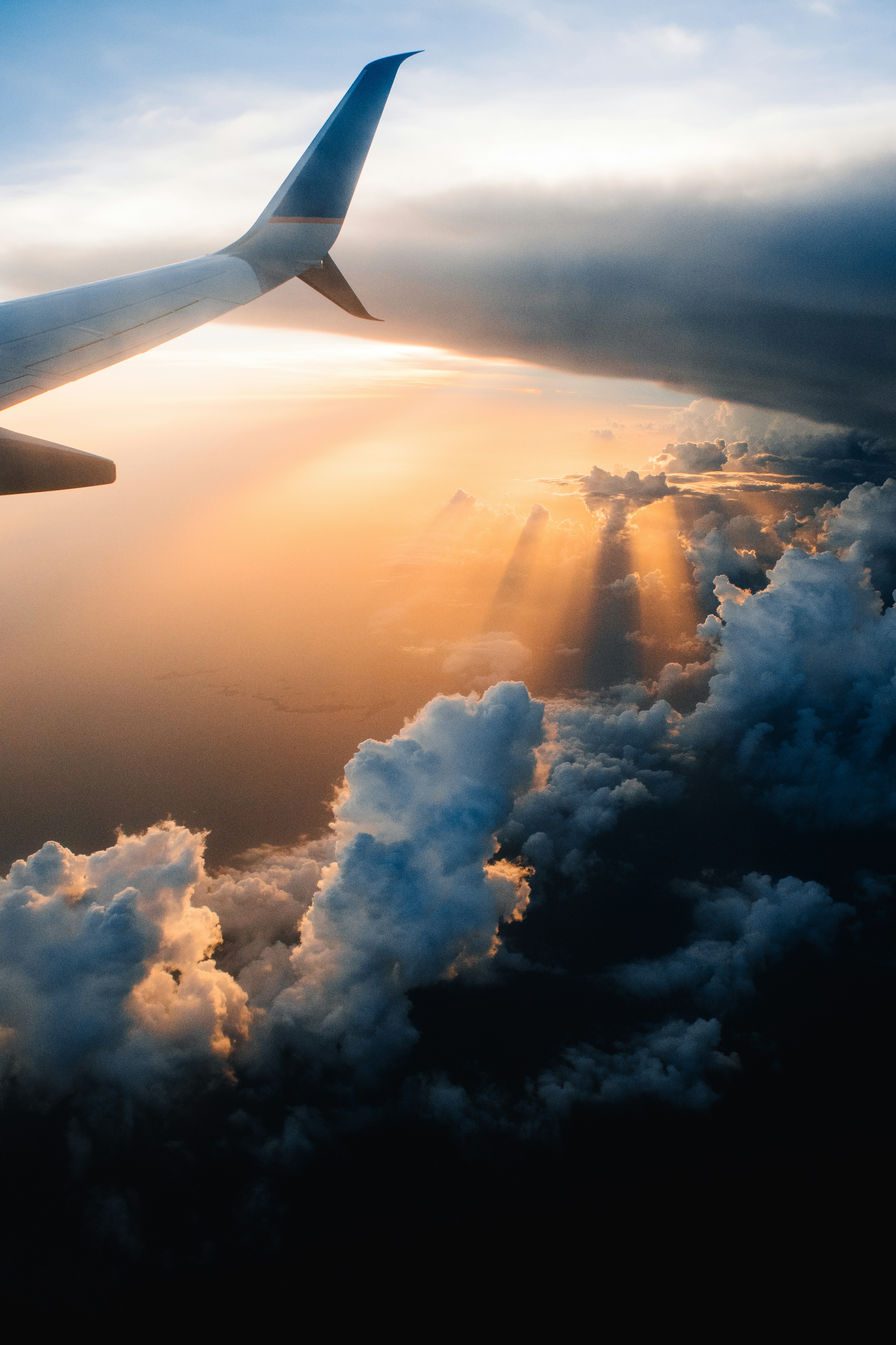 Airplane silhouetted against a golden sunset sky